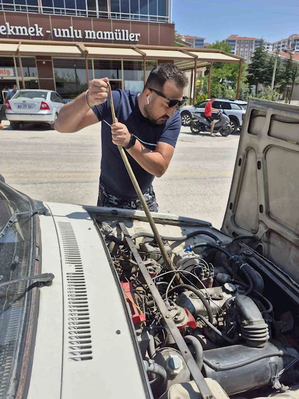 Aracın motoruna giren yılanı elindeki sopayla çıkardı
