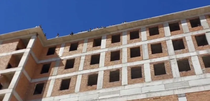 Maaşlarını alamayan işçiler binanın tepesine çıktı
